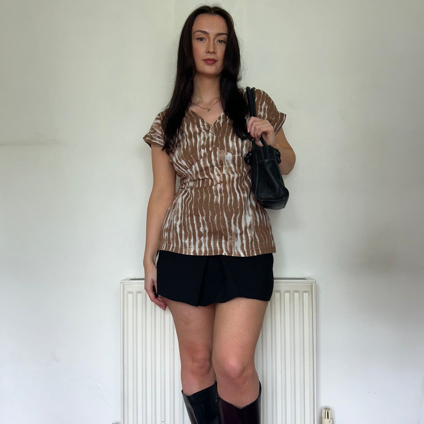 brown and white vintage top shown on a model wearing a black mini skirt and black shoulder bag with knee high boots