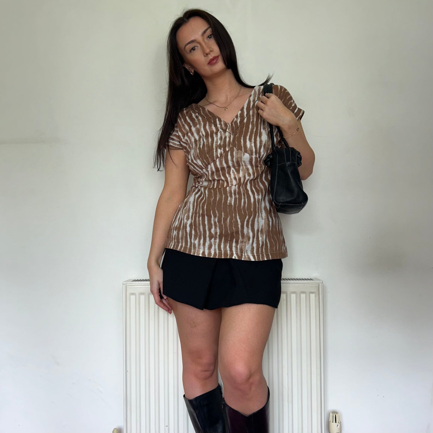 brown and white vintage top shown on a model wearing a black mini skirt and black shoulder bag with black boots