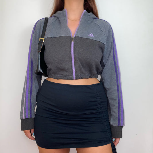 grey and purple 1/4 zip cropped hoodie with purple adidas logo shown on a model wearing a black skirt and a black shoulder bag