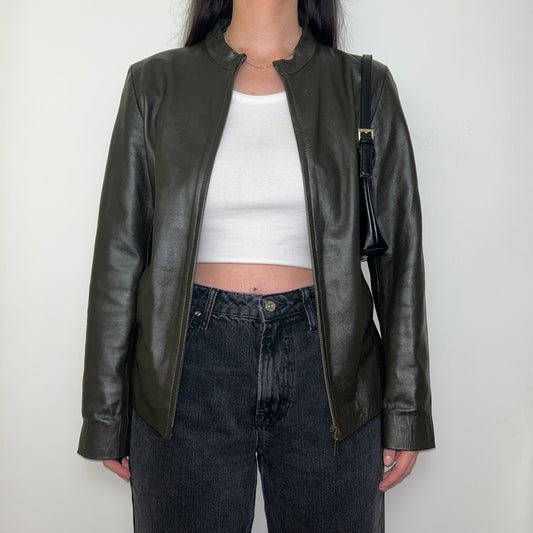 khaki leather bomber jacket shown on a model wearing a white crop top and black jeans with a black shoulder bag