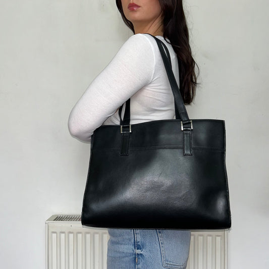 black leather vintage messenger bag shown on a models shoulder