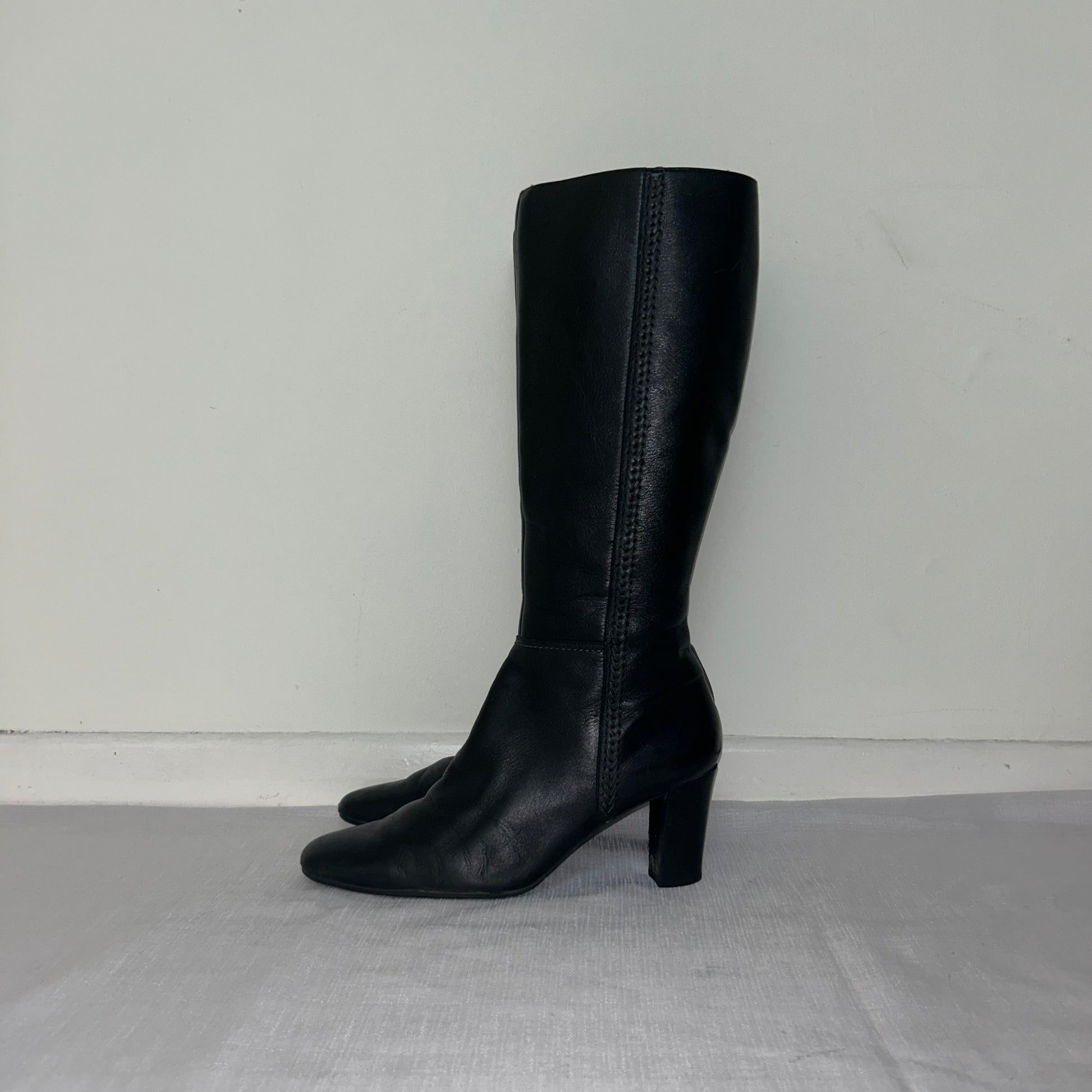 black knee high real leather boots shown on a white background