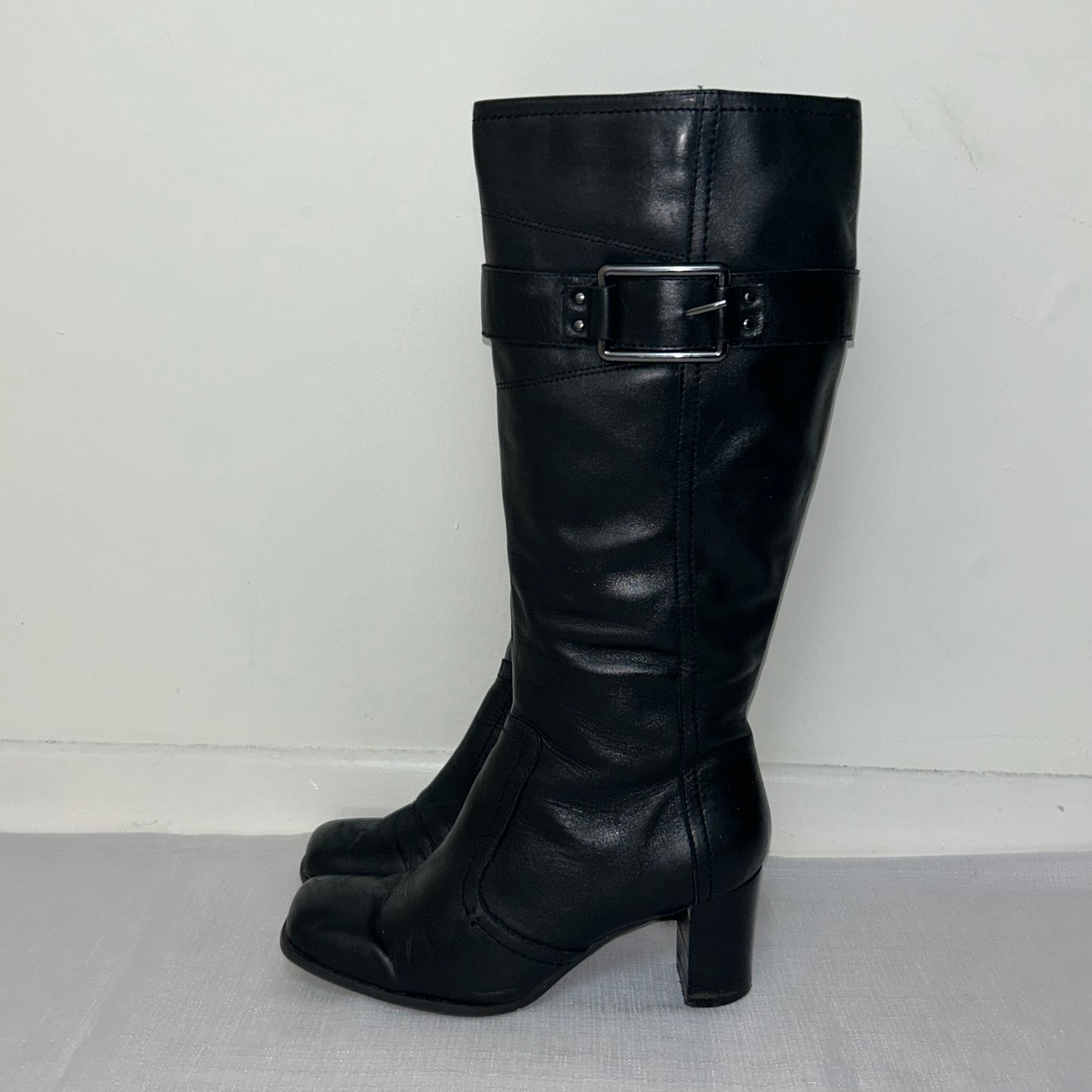 black knee high real leather boots shown on a white background