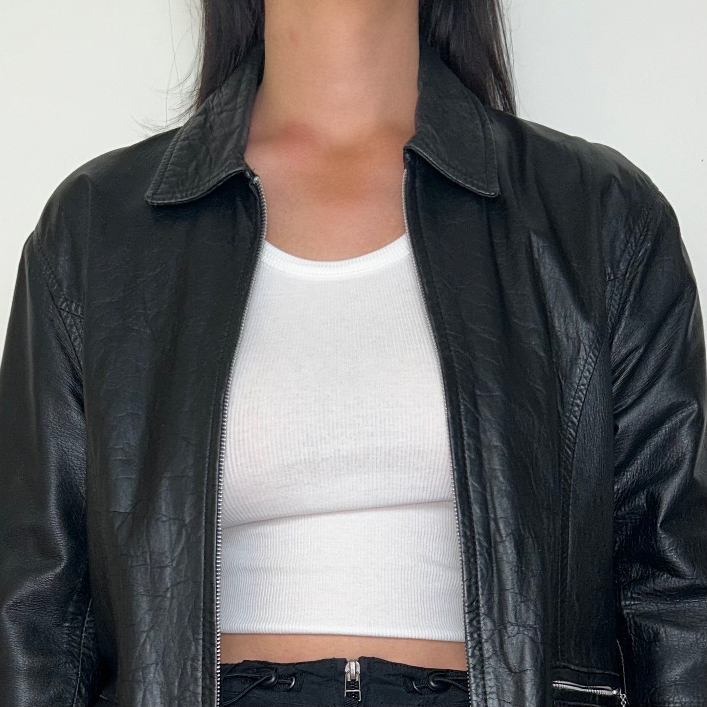 close up of black leather zip up jacket shown on model