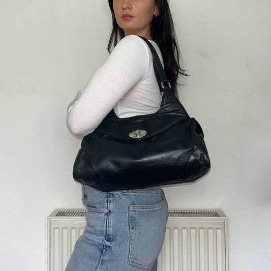 black leather shoulder bag shown a models shoulder