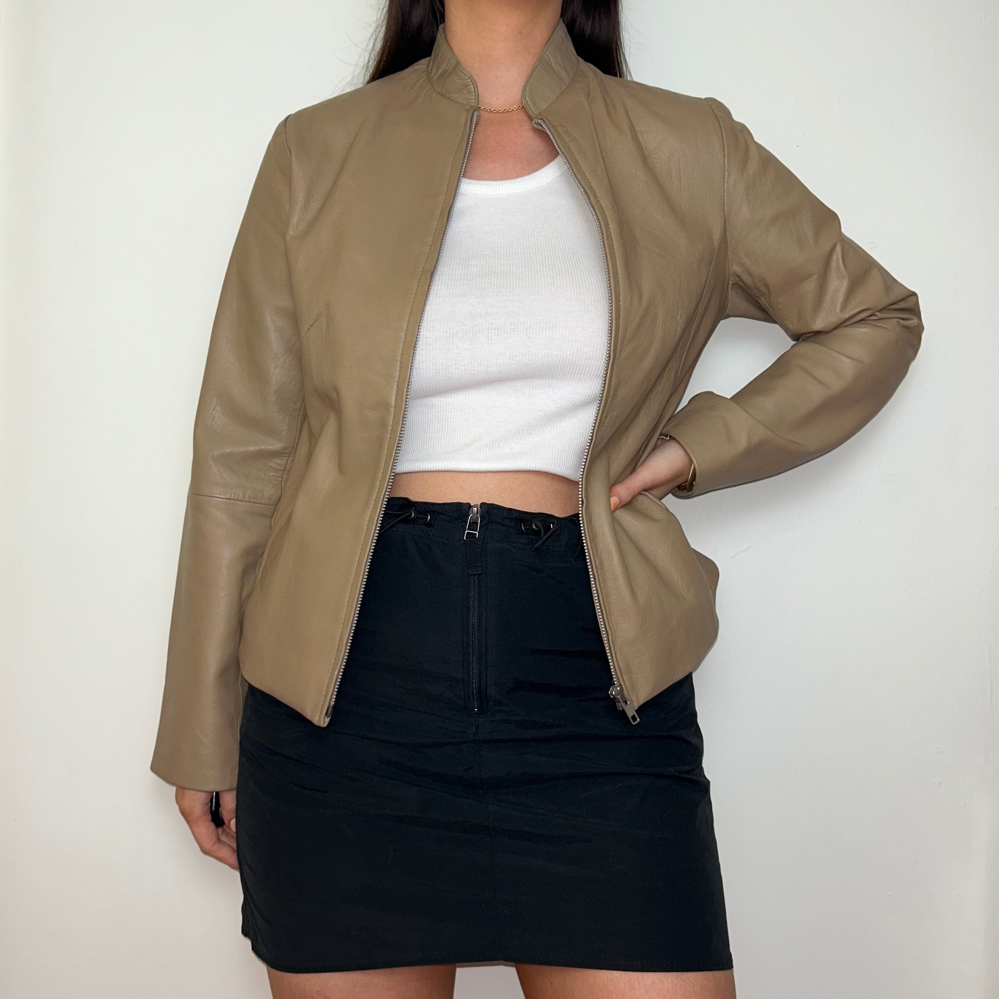 tan beige real leather jacket shown on a model wearing a white crop top and black mini skirt