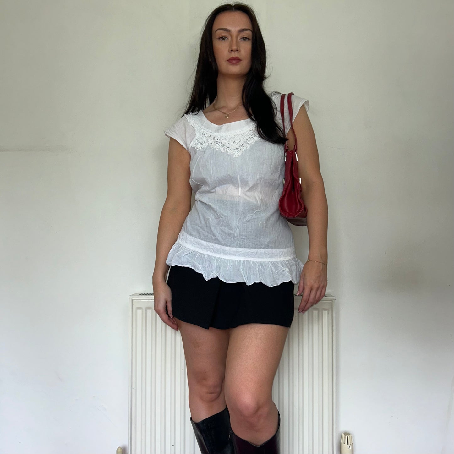 vintage white blouse top shown on a model wearing a black mini skirt and black boots and a red bag