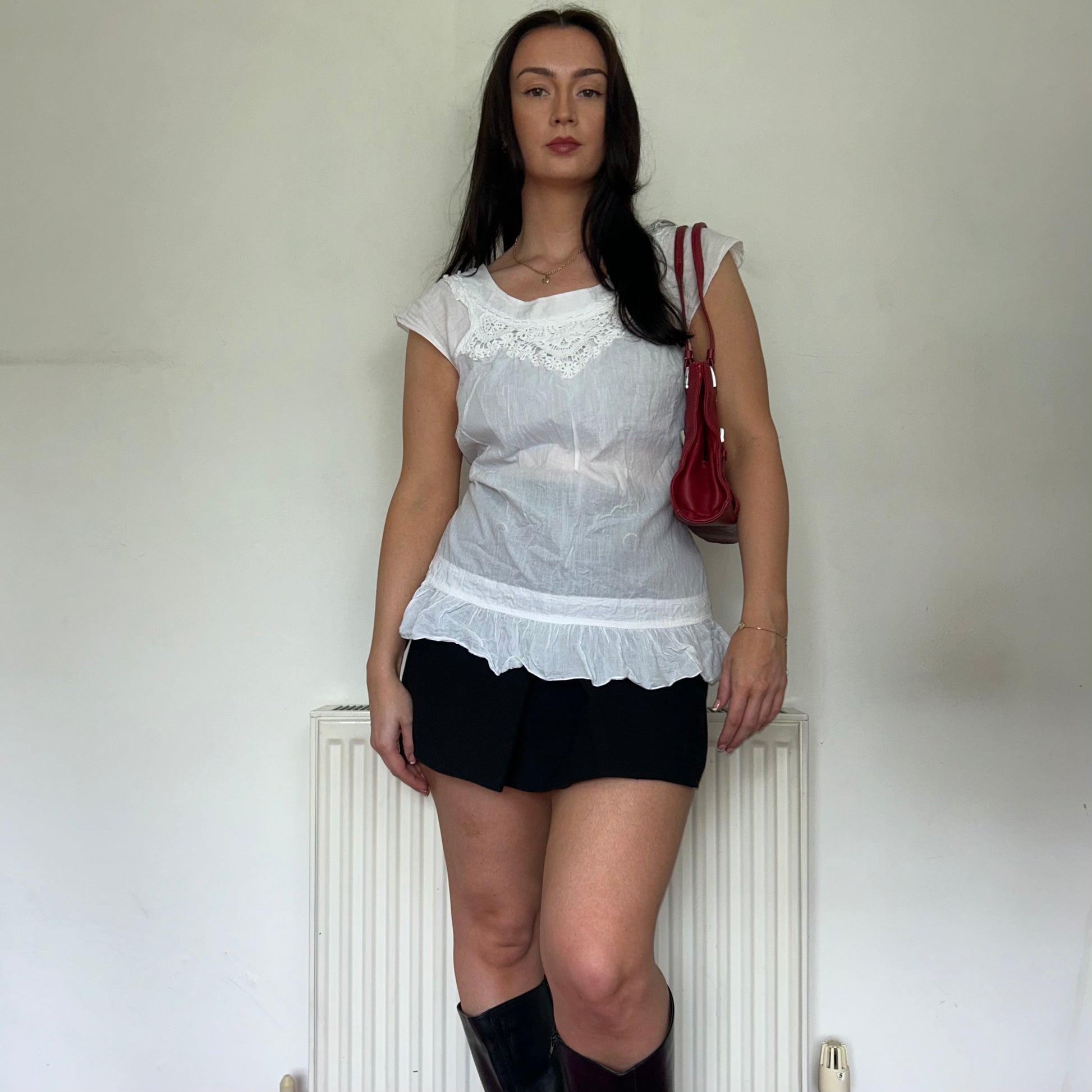 vintage white blouse top shown on a model wearing a black mini skirt and black boots and a red bag