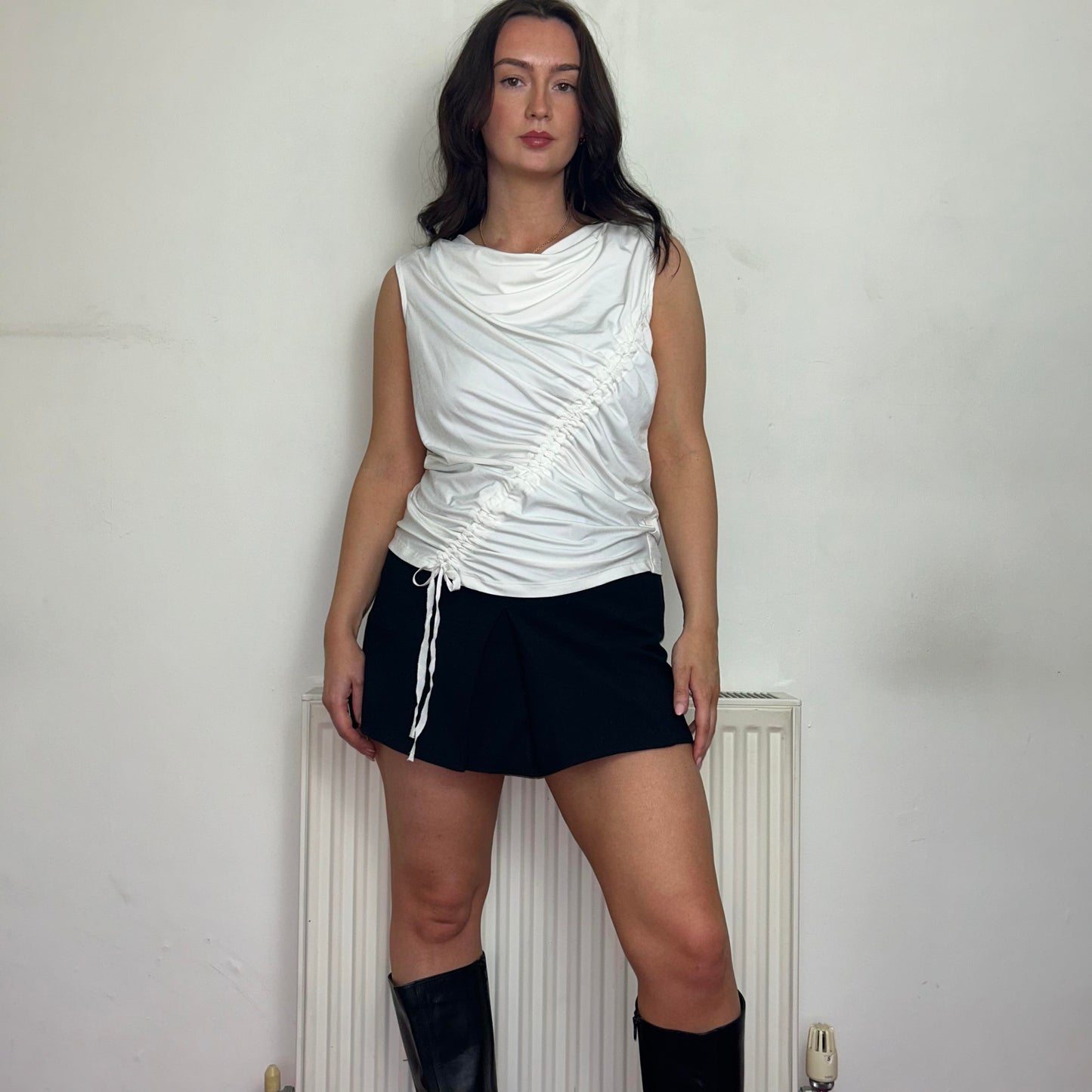 white rouched vintage top shown on a model wearing a black mini skirt and black boots