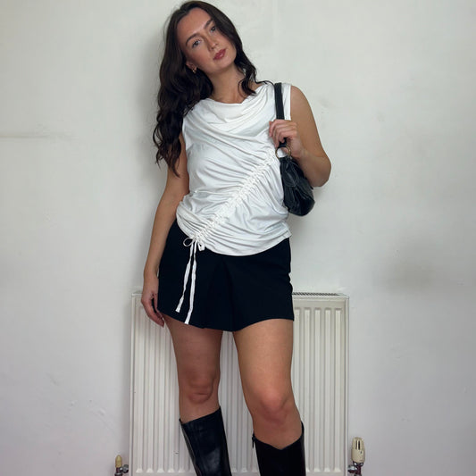 white rouched vintage top shown on a model wearing a black mini skirt