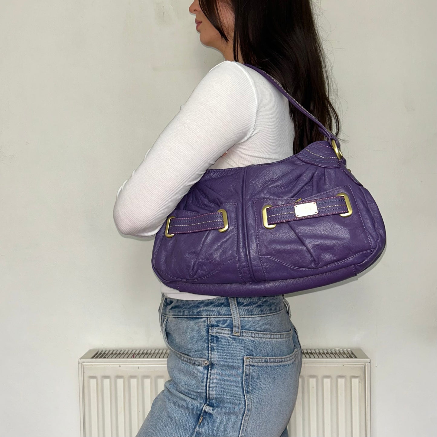 purple vintage leather shoulder bag shown on a models shoulder