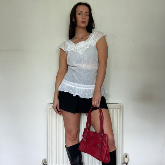 vintage white blouse top shown on a model wearing a black mini skirt and black boots