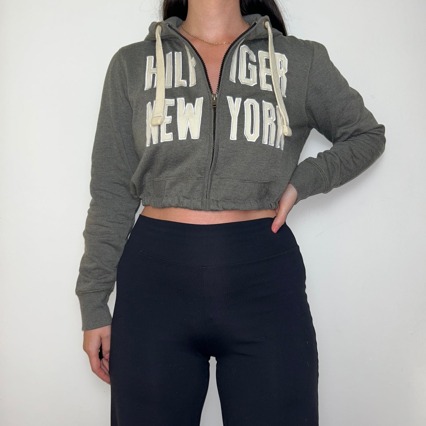 grey tommy hilfiger cropped hoodie shown on a model wearing black trousers
