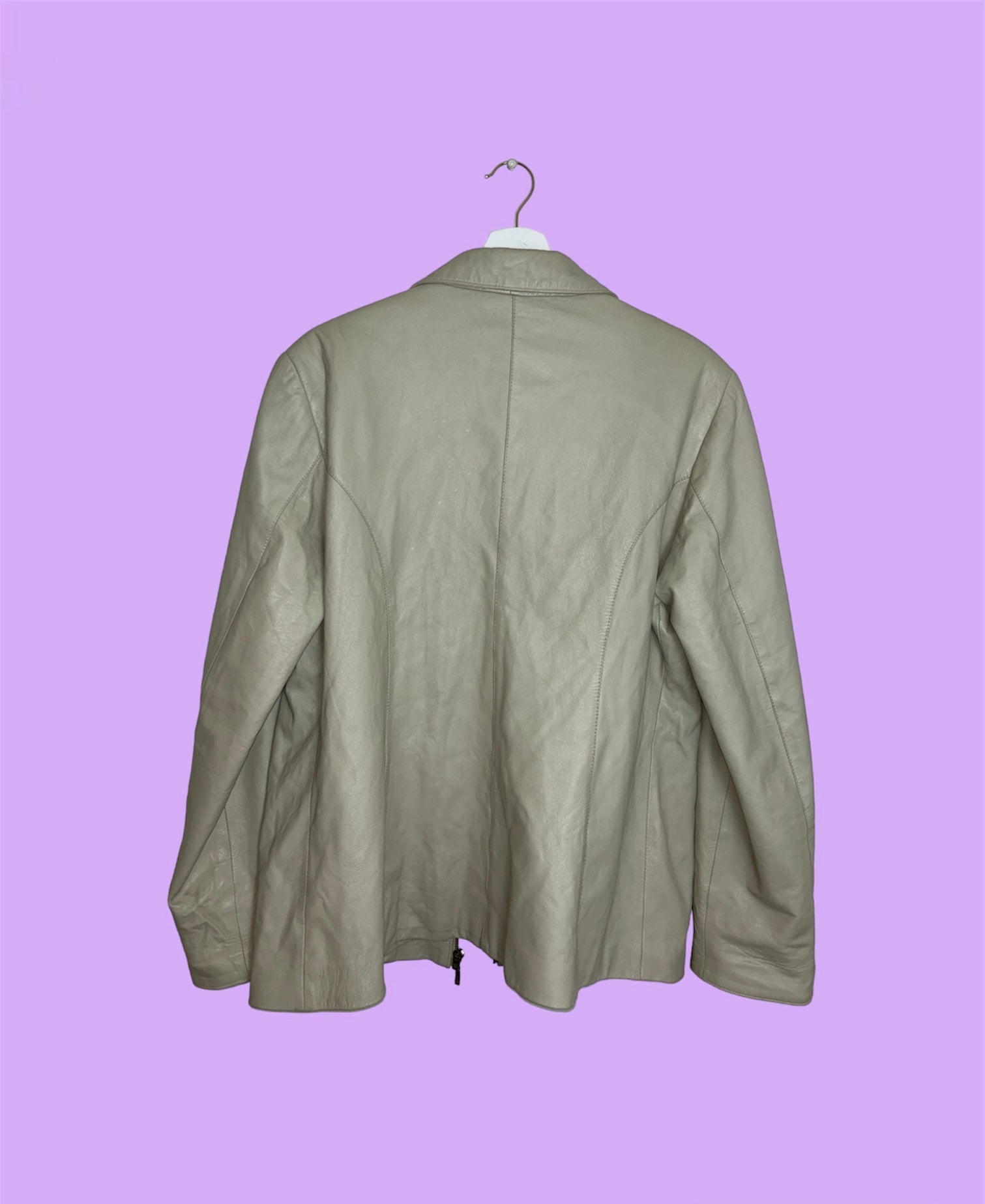back of beige leather zip up jacket shown on a lilac background