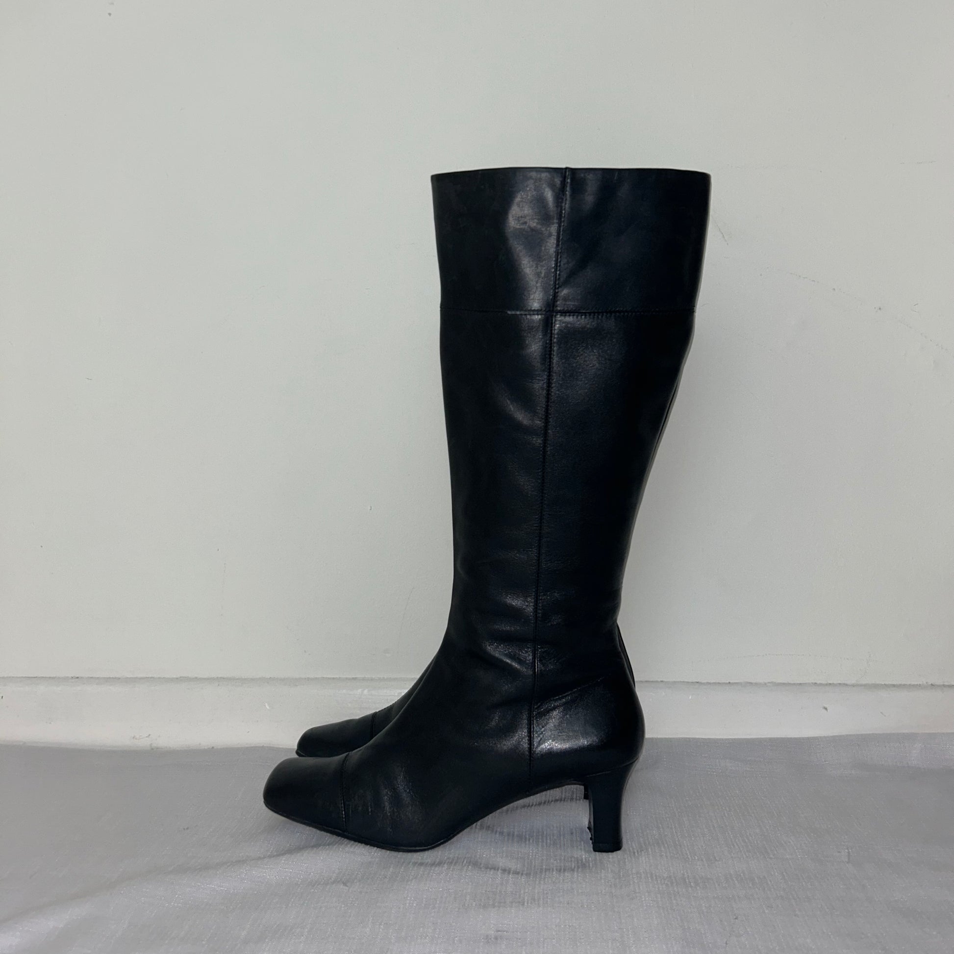 vintage black knee high leather boots shown on a white background