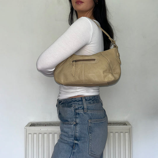 beige leather mini shoulder bag shown on a models shoulder