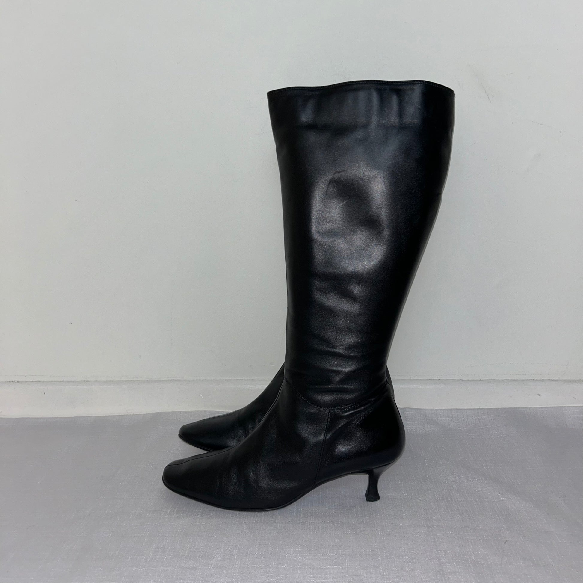 black knee high boots shown on a white background