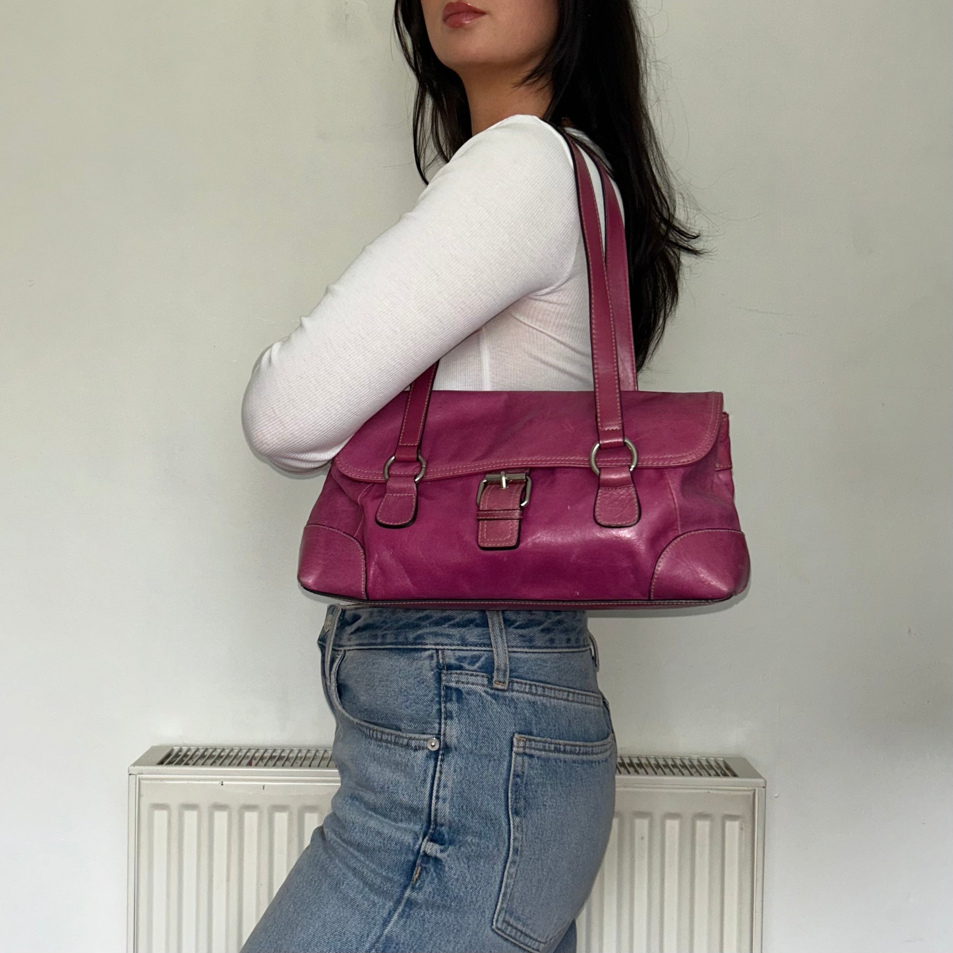 pink leather vintage bag shown on a models shoulder