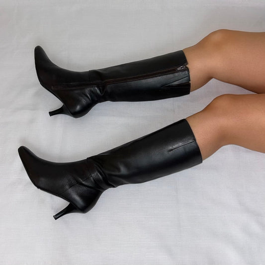dark brown leather knee high boots shown on a models legs laid on a white background