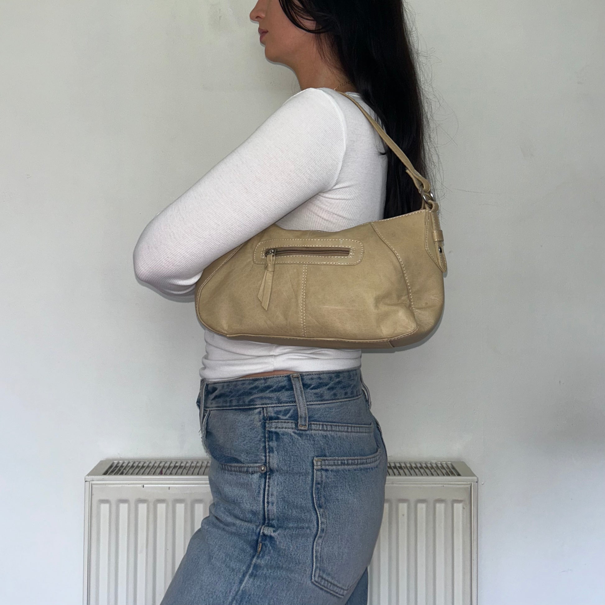 beige leather mini shoulder bag on a models shoulder