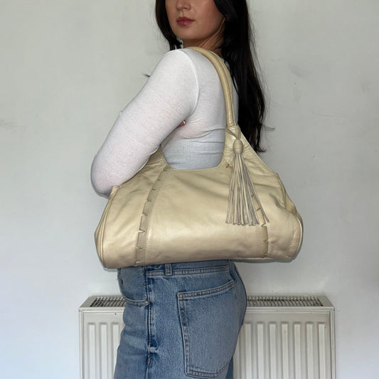 beige leather vintage shoulder bag shown on a models shoulder