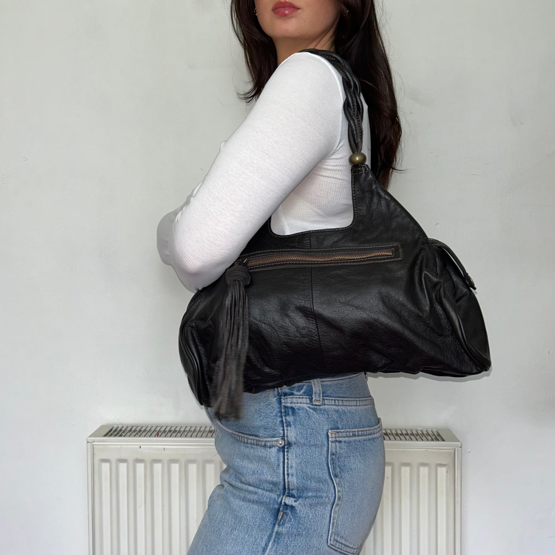 dark brown leather shoulder bag shown on a models shoulder