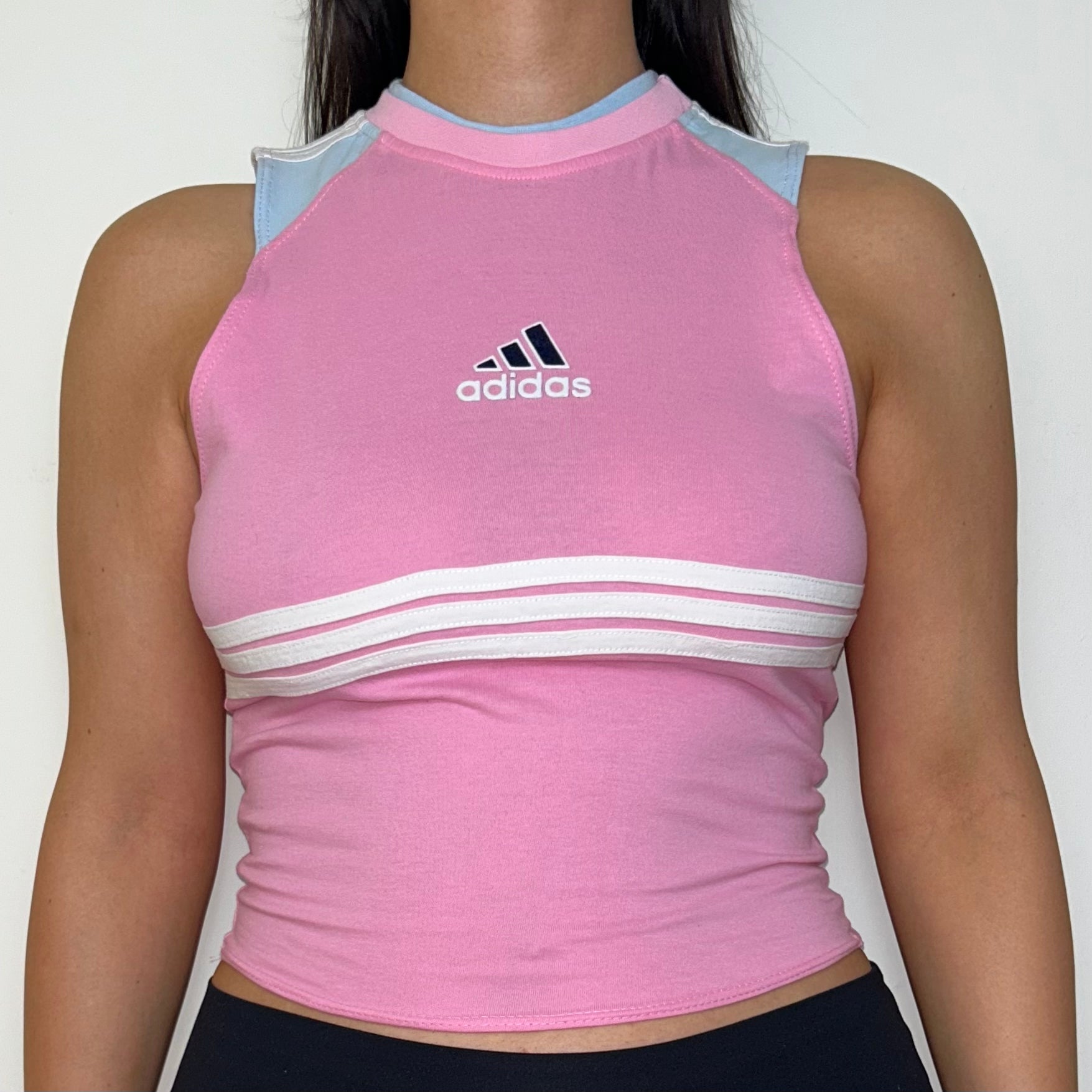 close up of pink sleeveless crop top with black and white adidas logo