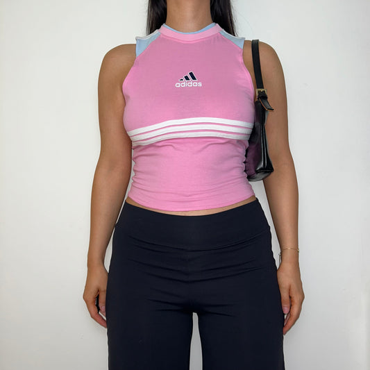 pink sleeveless crop top with black and white adidas logo shown on a model wearing black trousers and a black shoulder bag