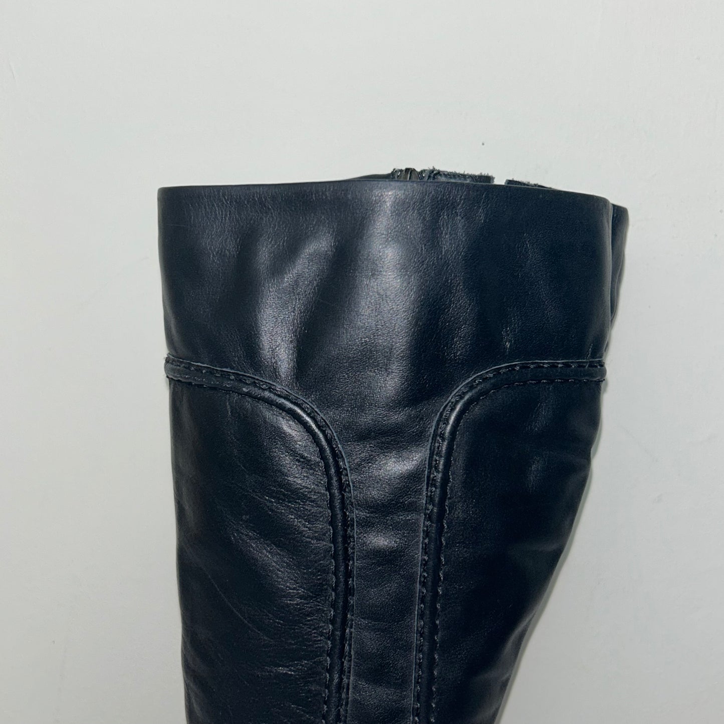 close up of black knee high boots shown on a white background