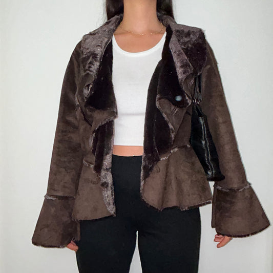 brown faux fur coat shown on a model wearing a white crop top and black trousers with a black shoulder bag