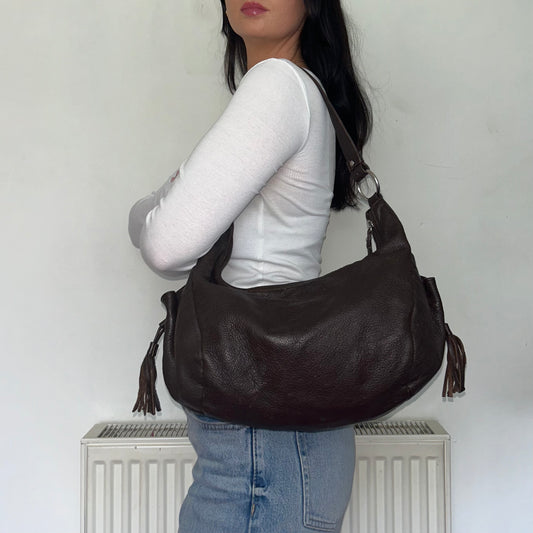 brown leather vintage shoulder bag shown on a models shoulder