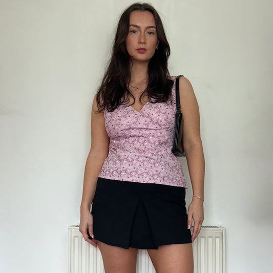 pink cami vintage top shown on a model wearing a black skirt and black bag