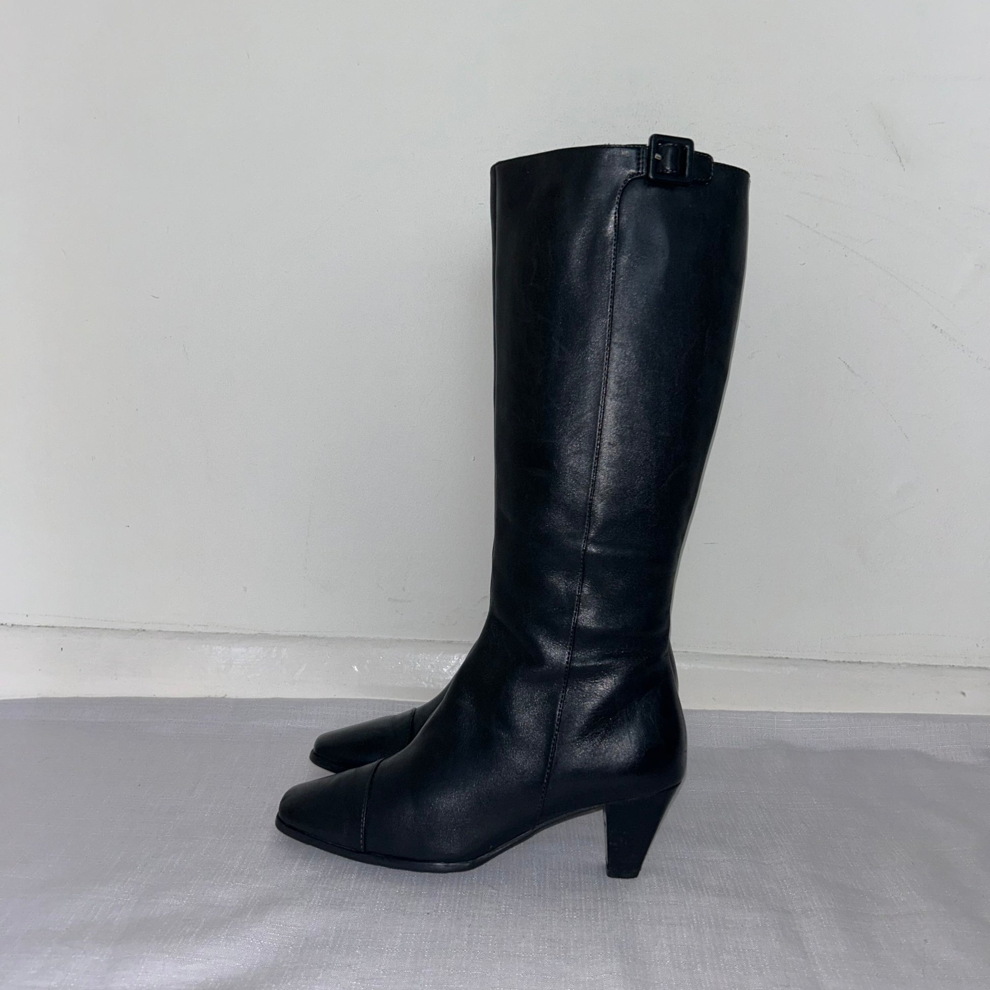 black knee high boots shown on a white background