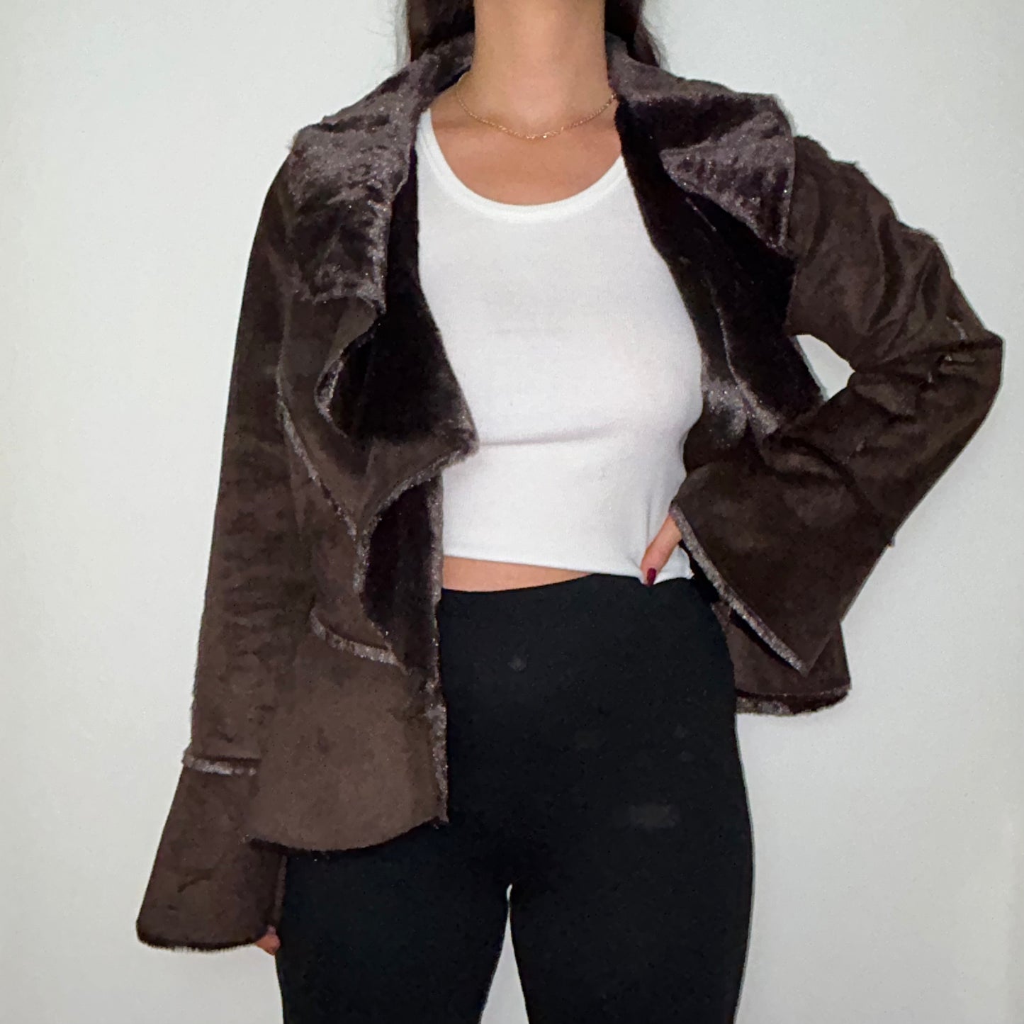 brown faux fur coat shown on a model wearing a white crop top and black trousers