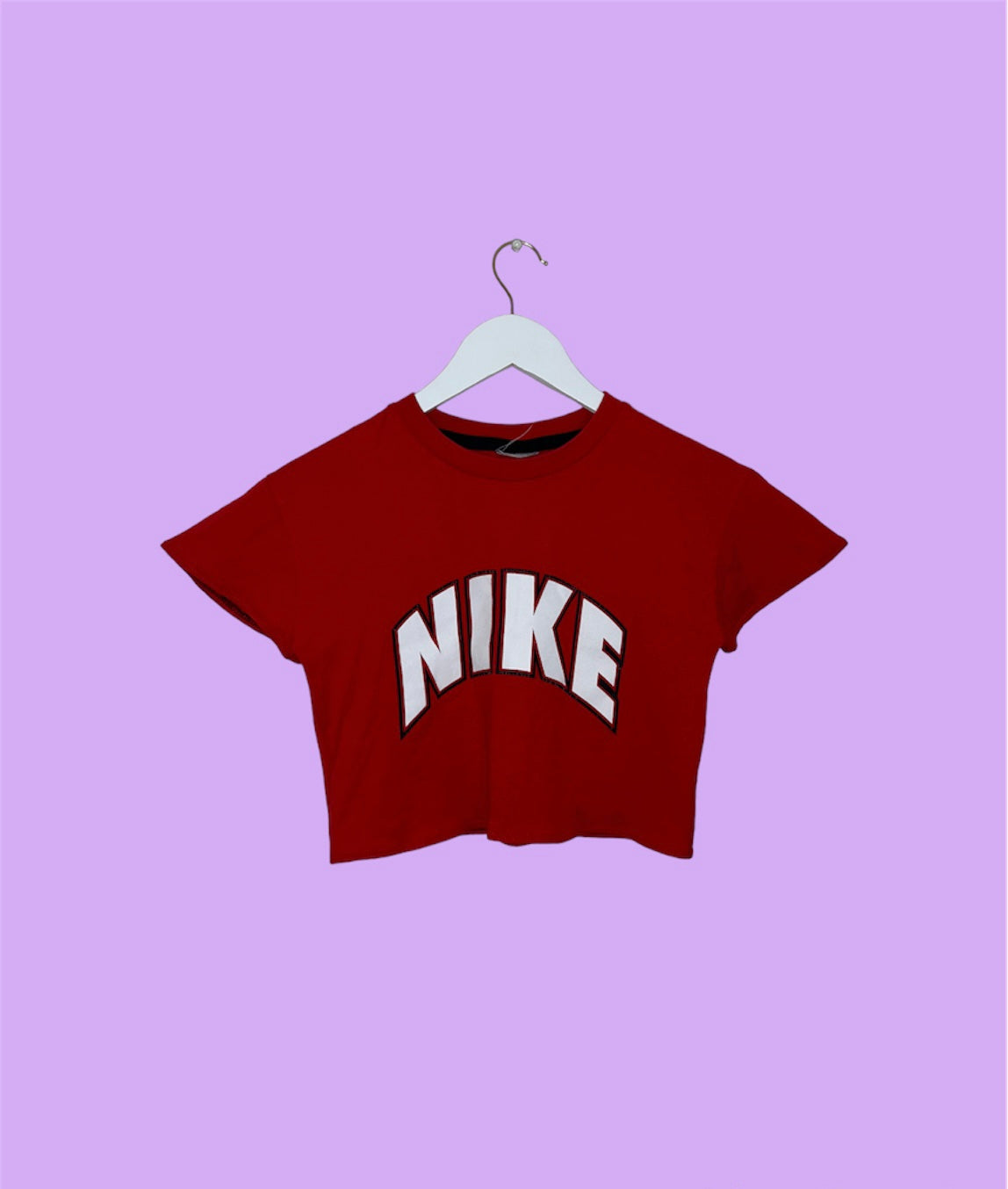 red short sleeve crop top with white nike logo shown on a lilac background
