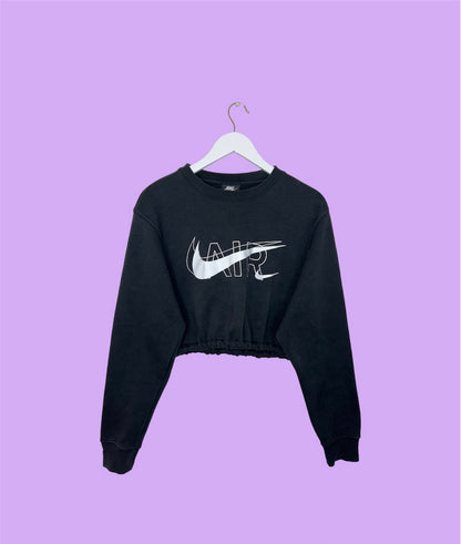 black cropped sweatshirt with white nike air logo shown on a lilac background