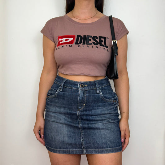 pink short sleeve crop top with black diesel logo shown on a model wearing a denim skirt and black shoulder bag