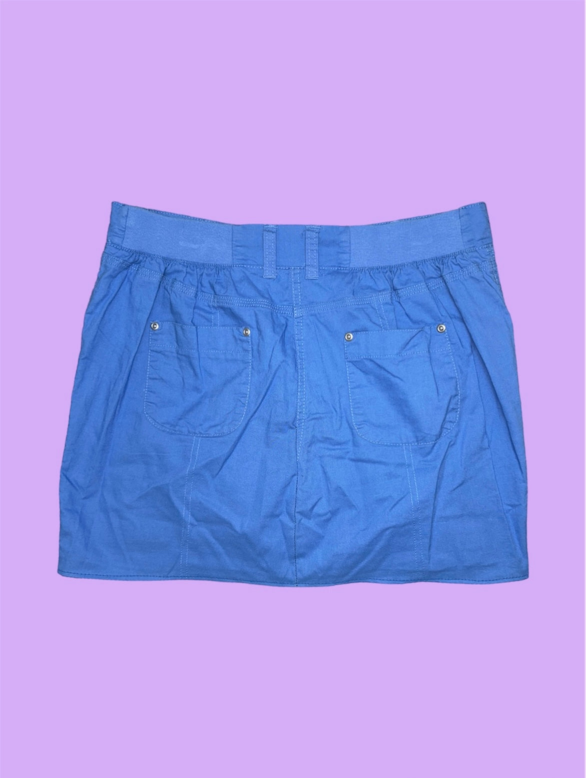 blue mini cargo skirt shown on a lilac background