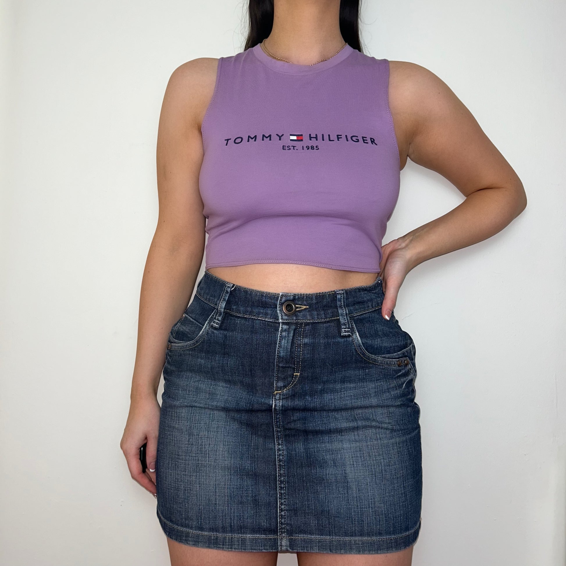 lilac sleeveless crop top with black tommy hilfiger logo shown on a model wearing a denim mini skirt