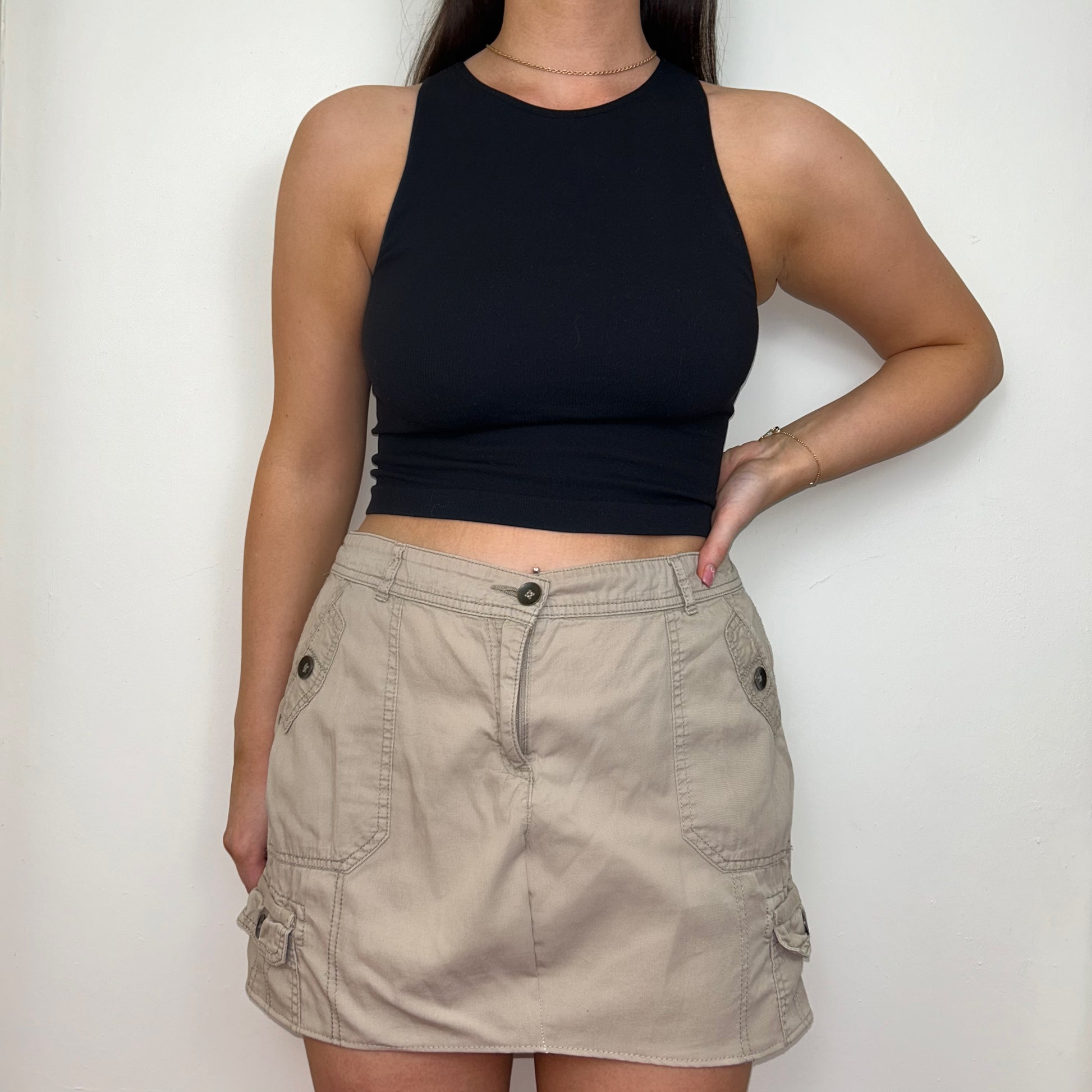 beige cargo mini skirt shown on a model wearing a black crop top