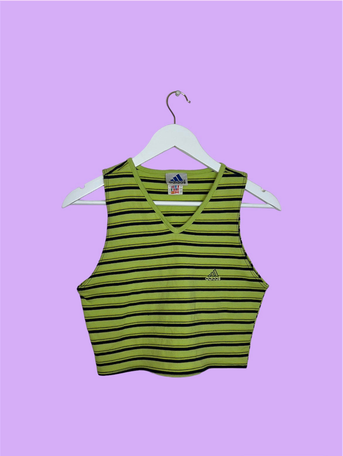 green and black sleeveless crop top with small adidas logo shown on a lilac background