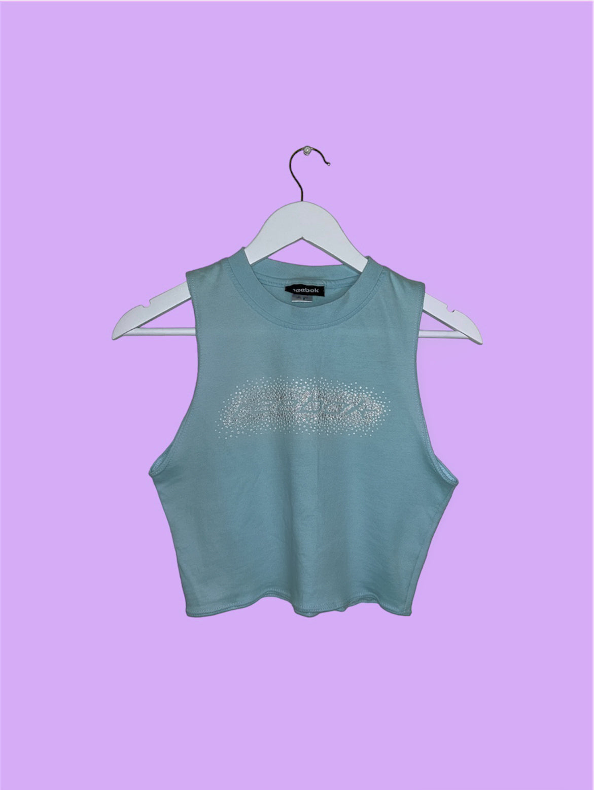 light blue sleeveless crop top with gem reebok logo shown on a lilac background