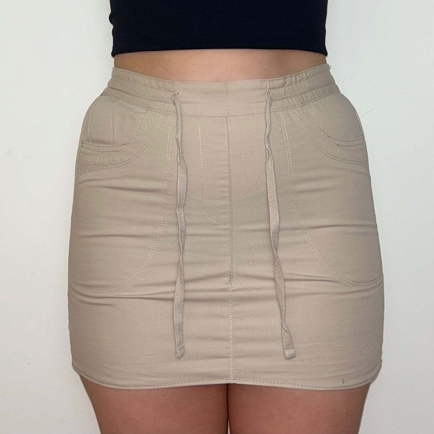 close up of beige mini cargo skirt shown on a model