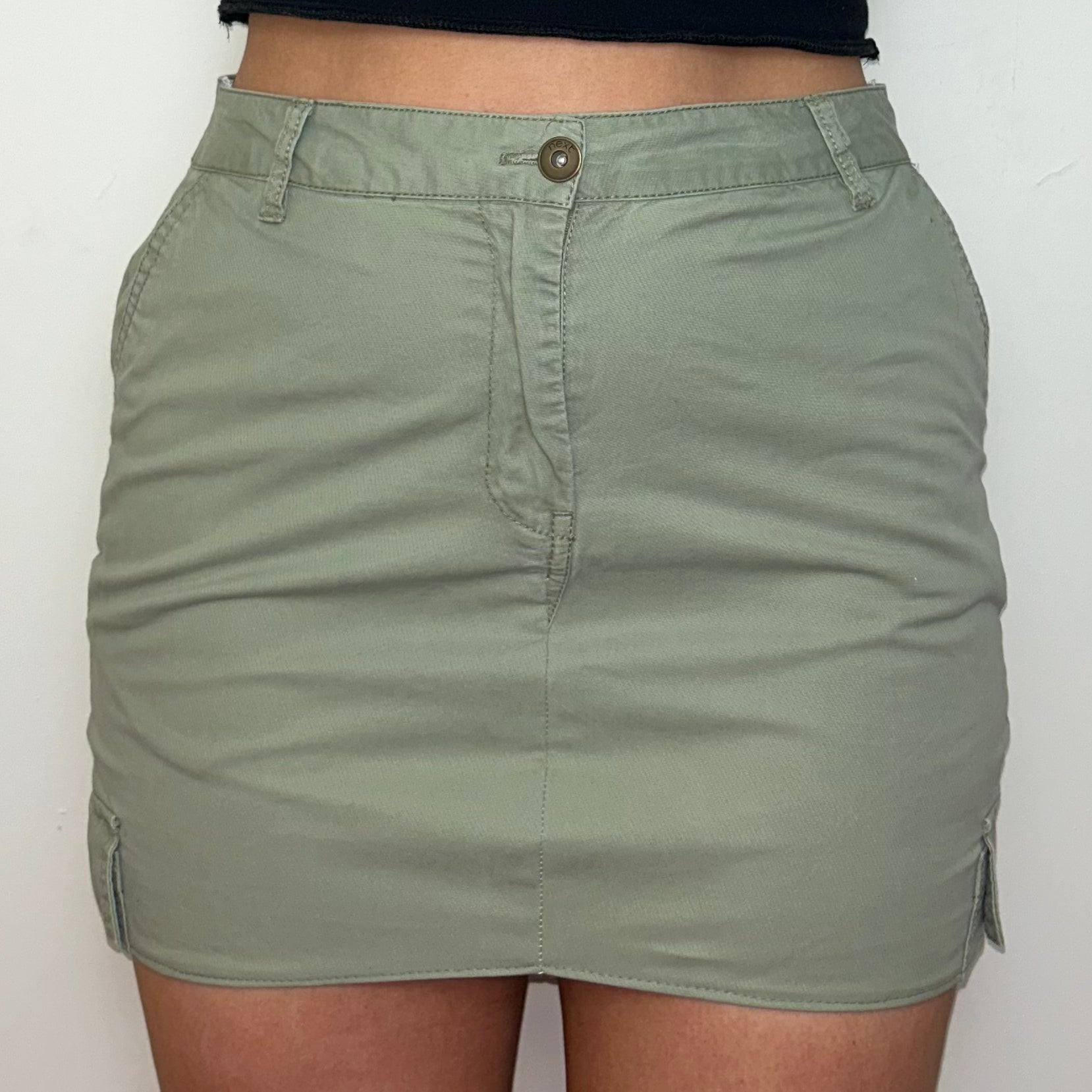 close up of light green cargo mini skirt shown on a model