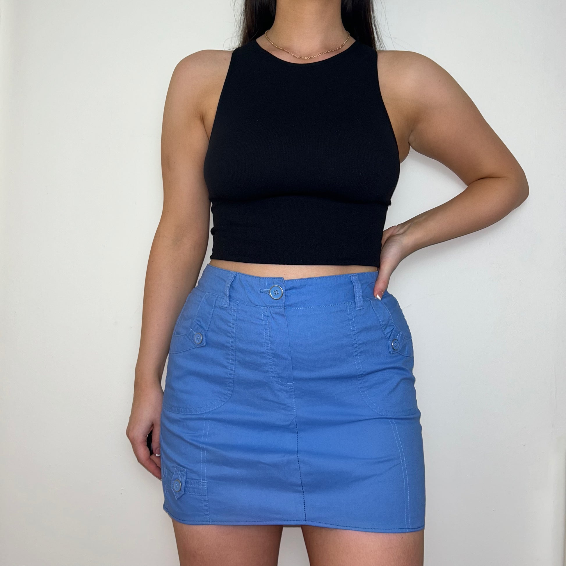 blue mini cargo skirt shown on a model wearing a black sleeveless crop top