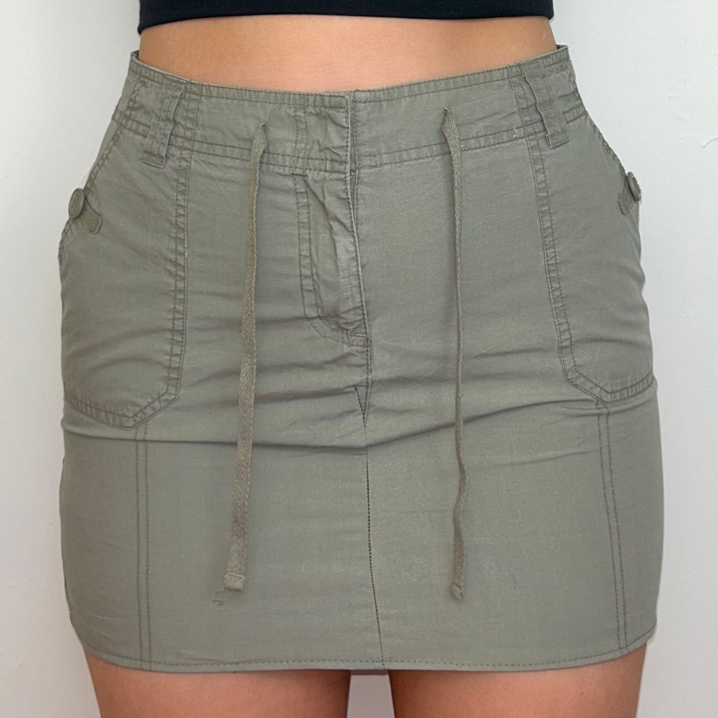 khaki grey mini cargo skirt shown on a model