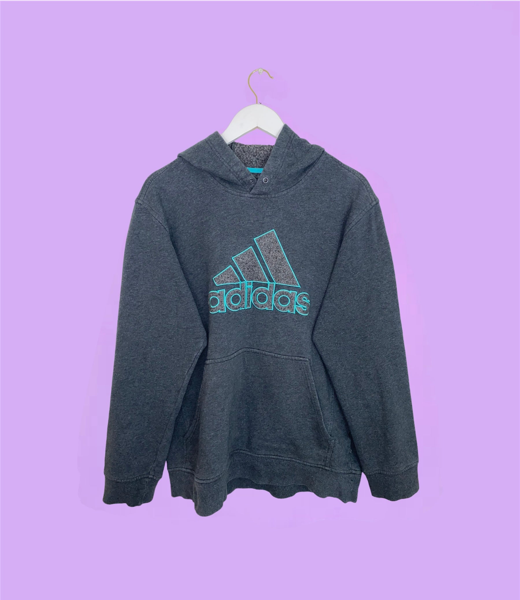 grey hoodie with blue adidas big text logo shown on a lilac background
