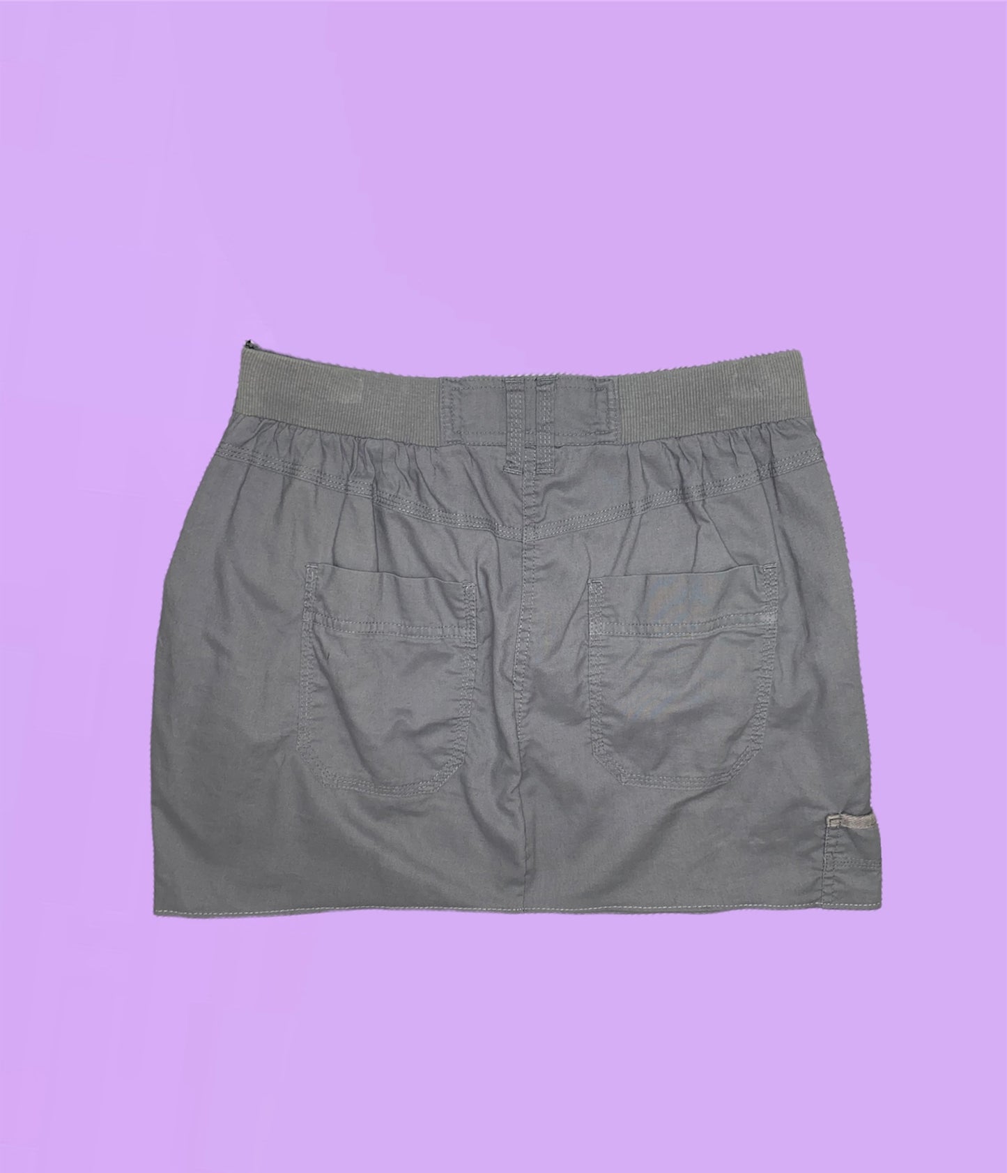 back of a grey mini cargo skirt on a lilac background