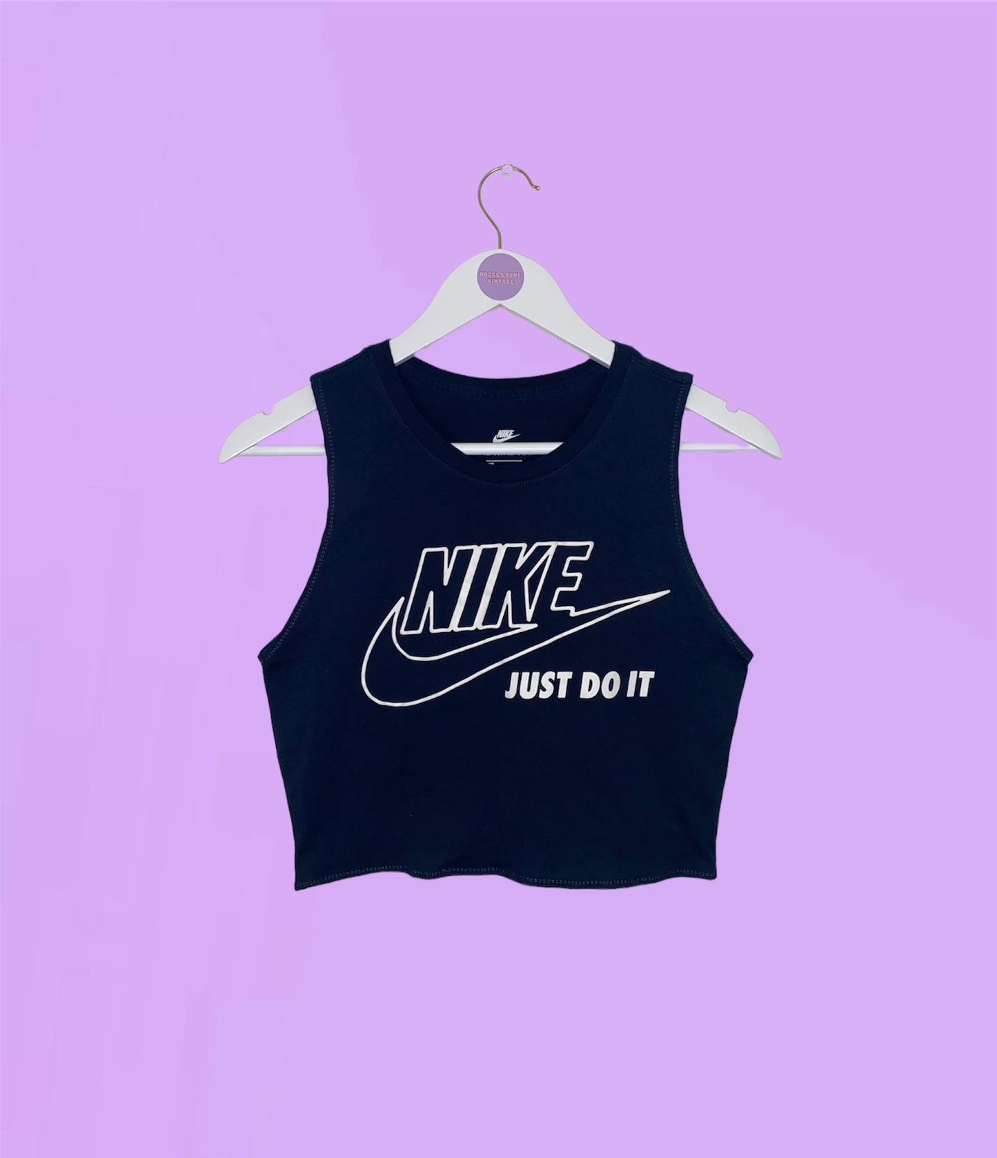 navy sleeveless crop top with white nike logo shown on a lilac background
