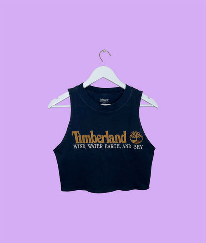 navy sleeveless crop top with orange and white timberland logo shown on a lilac background